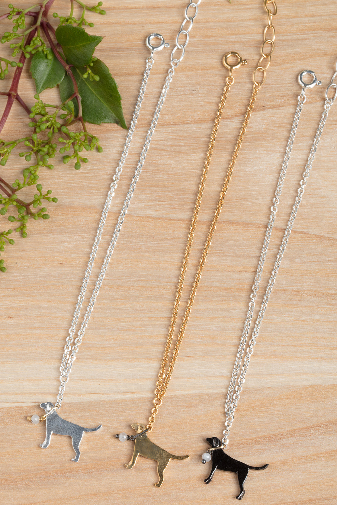 Solid silver, gold, and black necklaces with dog pendant detail