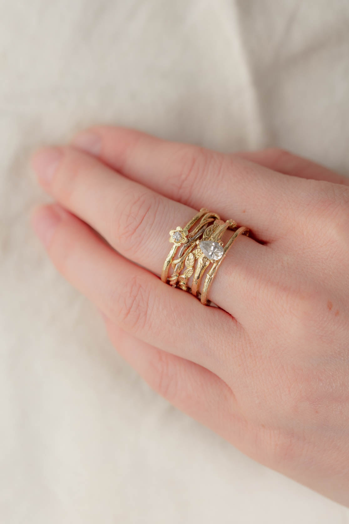 Our nature-inspired alternative wedding and engagement rings stacked on a finger. A delightful contrast of organic textures. 