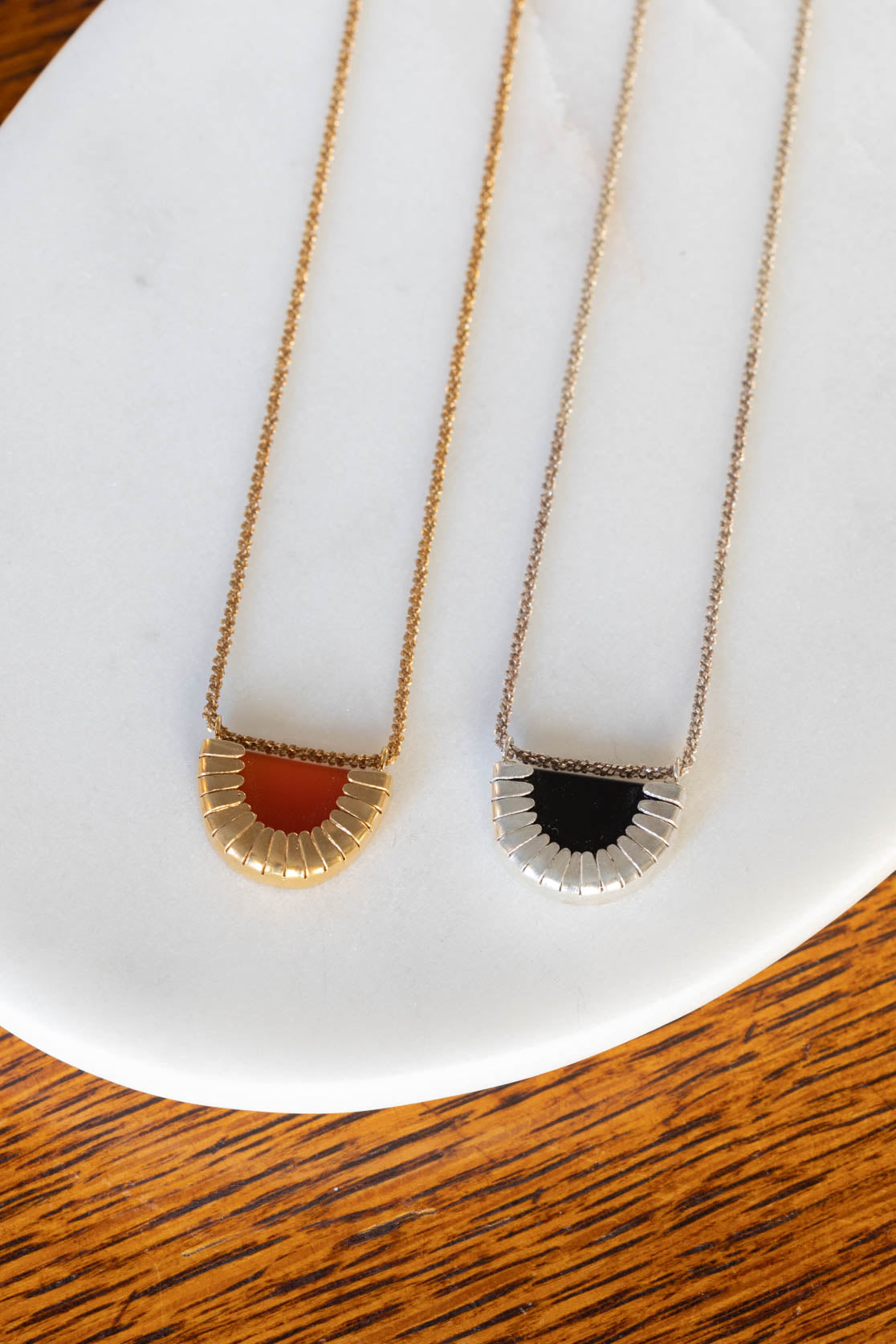 Gold and silver necklaces with black and orange detialing
