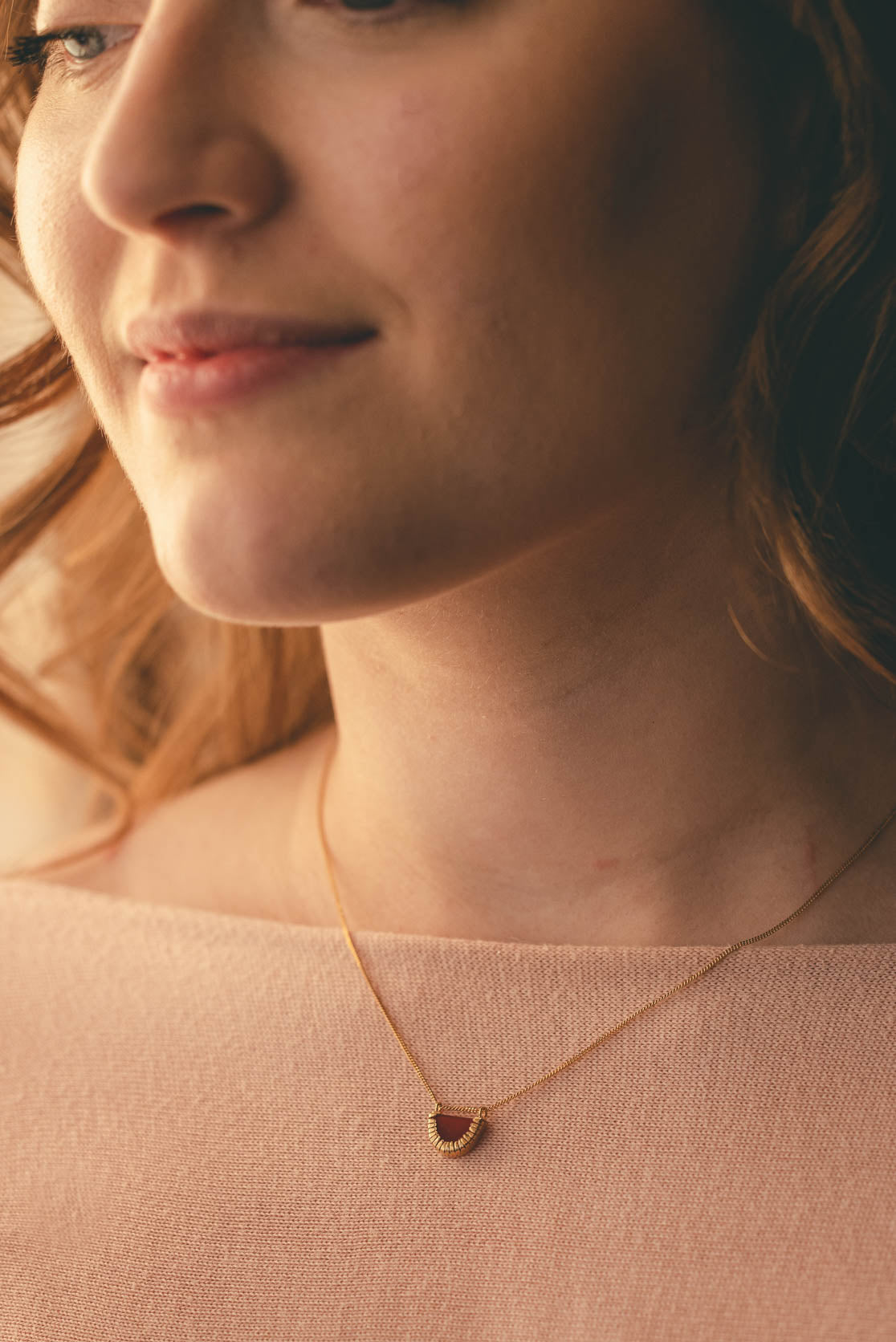 Woman wearing gold and orange deco necklace